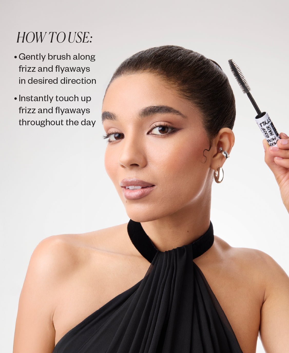 Woman holding a XL taming wand with text on how to use it, against a plain background