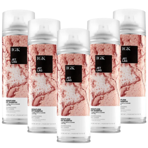 Five bottles of IGK Jet Lag dry shampoo with pink marbled design.
