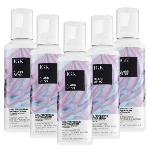 Five bottles of IGK Class of '93 Curl Perfecting Whipped Cream with colorful labels.